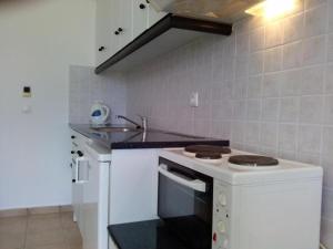 a small kitchen with a stove and a sink at Liberatos Village in Lassi