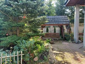 Noclegi u Janusza في Zalesie: شرفة خشبية صغيرة في حديقة