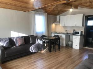 ein Wohnzimmer mit einem Sofa und einem Tisch sowie eine Küche in der Unterkunft Golden Lake Aparts in Koycegiz