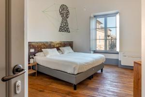 1 dormitorio con cama y ventana grande en TAG Guest House, en Viterbo