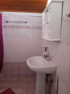 a bathroom with a white sink and a cabinet at Giota & Antonia Apartments in Koroni