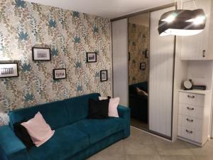 - un salon avec un canapé bleu et un miroir dans l'établissement Apartament Helena, à Międzyzdroje