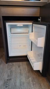 an empty refrigerator with its door open in a room at Nice Apartment in modern Center of Düsseldorf in Düsseldorf