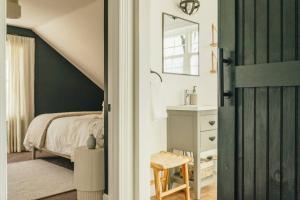1 dormitorio con cama y puerta con espejo en Hot Tub & Catskill Hiking, 15min from Hudson & Amtrak en Catskill