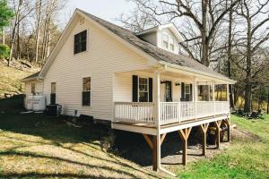 a small white house with a porch on a lawn at Hot Tub & Catskill Hiking, 15min from Hudson & Amtrak in Catskill