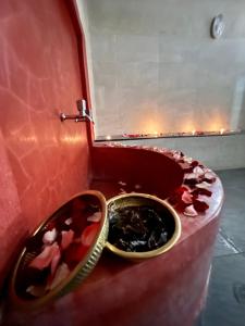 a bathroom with a red toilet with flowers on it at Vent Des Dunes in Essaouira