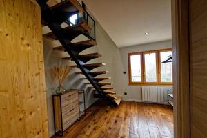 una escalera de caracol en una habitación con suelo de madera en Les balcons de Cuttura 2 chez Ô JurassiK, en Cuttura