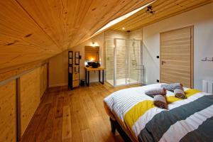 sypialnia z łóżkiem i drewnianym sufitem w obiekcie Les balcons de Cuttura 2 chez Ô JurassiK w mieście Cuttura