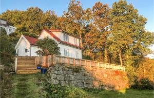 une maison blanche avec une clôture et des arbres dans l'établissement Beautiful Home In Hommersk With Wifi, à Hommersåk