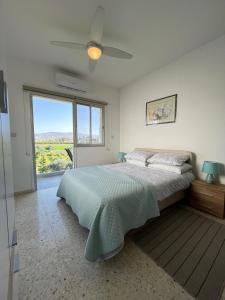 una camera con letto e ventilatore a soffitto di White House studio with sea view and parking a Polis Chrysochous