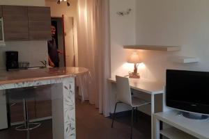 a kitchen with a counter and a desk with a television at COSY FLAT in Bussy-Saint-Georges