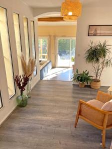 sala de estar con suelo de madera, sofá y ventanas en Villa d'architecte avec piscine et grand jardin en Marsella