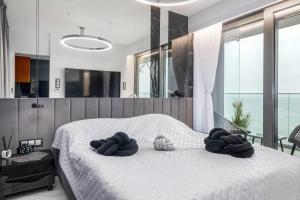 sypialnia z białym łóżkiem i ręcznikami na nim w obiekcie Holiday Exclusive w Rewalu