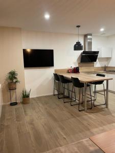 eine Küche mit einem Tisch und Stühlen sowie einem TV in der Unterkunft Appartement Jungle centre confort et spacieux netflix wifi gratuit in Saint-Étienne