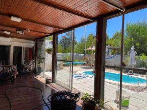 eine abgeschirmte Veranda mit Poolblick in der Unterkunft Los Fernández in Jaureguiberry