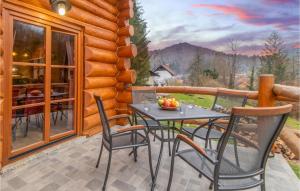una mesa y sillas en el porche de una cabaña de madera en 3 Bedroom Nice Home In Cabar, en Čabar