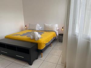 a bedroom with a yellow bed with towels on it at Manaeva L3 in Papeete
