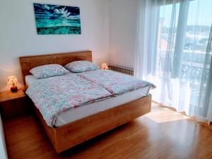 a bedroom with a bed and a large window at Apartments Tiho&Marija in Tribunj