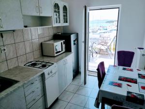 une petite cuisine avec une table et un four micro-ondes dans l'établissement Apartments Tiho&Marija, à Tribunj