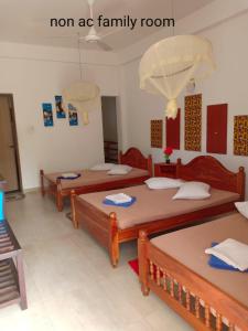 a room with three beds in a room at Hotel Senora in Kataragama
