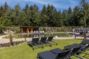 皮得斯费尔德黑德加鲁德酒店的后院设有椅子、池塘和小屋