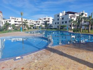 une grande piscine avec des bâtiments en arrière-plan dans l'établissement la Cassia Cabo Appartement, à Cabo Negro
