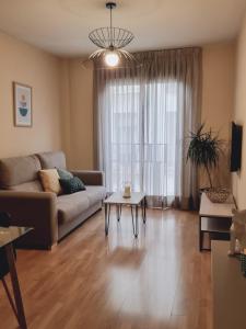 sala de estar con sofá y mesa en Apartamentos Salvia 4, en Madrid
