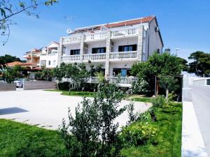 - un bâtiment blanc avec un balcon dans une rue dans l'établissement Apartments Tiho&Marija, à Tribunj