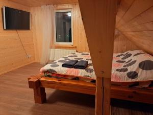 een slaapkamer met een bed in een houten hut bij Saules Rats Apartamenti in Madona