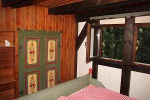 a room with a door and a bed and two windows at Black Forest House in Wolfach