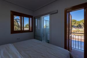 マニセスにあるVilla Huerta 1 Manises, jacuzzi, sauna, piscinaのベッドと2つの窓がある寝室 +104枚の写真