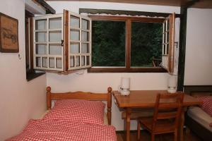 a bedroom with a bed and a desk and a window at Black Forest House in Wolfach