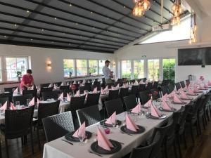 una habitación con mesas y sillas con servilletas rosas. en Oldfruen - Rooms & Apartments, en Bøtø By