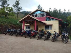 a group of motorcycles parked in front of a building at Kanasucoffeenadu in Attigundi
