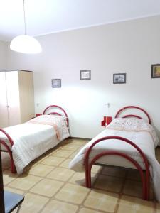 due letti in una stanza con pareti bianche di Giò & Giò Garibaldi-Nesima a Catania