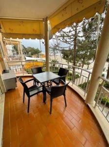 a patio with a table and chairs on a balcony at Lovely 2 bedroom unit with beach view in Golem