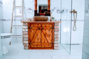 a bathroom with a wooden door and a sink at Kata Cottage in Szanda