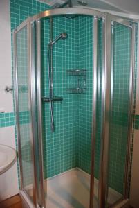 uma casa de banho com azulejos verdes, um chuveiro e um WC. em The Elephants Nest Inn em Marytavy