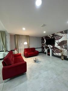 a living room with two red couches and a tv at Hotel Concorde Fiera in Saronno