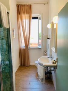 a bathroom with a sink and a window and a shower at Podere Gradisca in Alberese