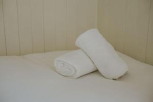 two white towels sitting on top of a bed at Snowdonia Shepherds Hut + Hot Tub in Barmouth