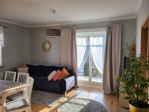 a living room with a couch and a window at Sunny Apartment - Bliżej Zdroju in Polanica-Zdrój
