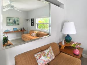 a living room with a couch and a mirror at South Beach Place - Vero Beach in Vero Beach