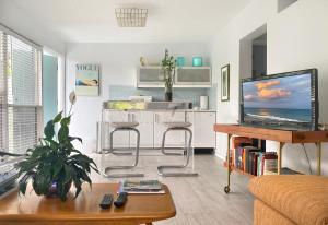 uma sala de estar com um sofá e uma televisão em South Beach Place - Vero Beach em Vero Beach