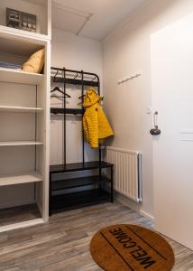 a walk in closet with a yellow coat on a rack at Cozy Studio - 7 min to Tampere Airport - Free Parking in Pirkkala