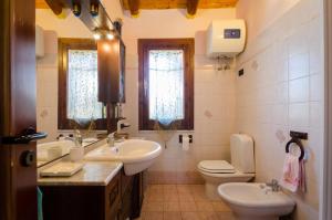 Villa Nina في أرينيلا: حمام فيه مغسلتين ومرحاض ومغسلة