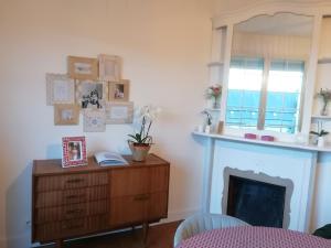 ein Wohnzimmer mit Kamin und einer Holzkommode in der Unterkunft Appartement 85 m2 centre-ville entièrement rénové in Le Creusot