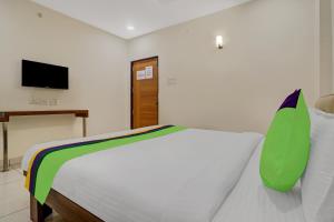 1 dormitorio con 1 cama blanca y TV en Treebo Trend Virat Residency - US Consulate en Hyderabad