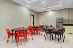 a dining room with tables and red chairs at Treebo Trend Virat Residency - US Consulate in Hyderabad