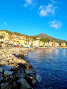 a beach with rocks and buildings and the water at Mojito's house in Rio Marina